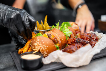 chef cooking fast food set on plate. burger, chicken wings on kitchen