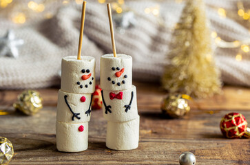 Happy marshmallow snowmen and Christmas winter holiday decorations.