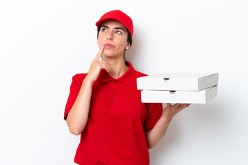 Pizza delivery caucasian woman with work uniform picking up pizza boxes isolated on white background having doubts while looking up