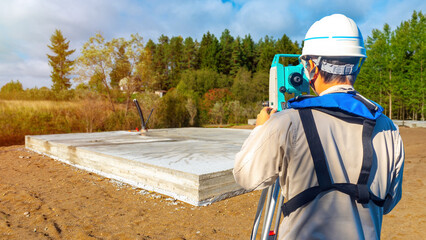 Man surveyor with his back to camera. Foundation construction work. Geodetic surveys during...