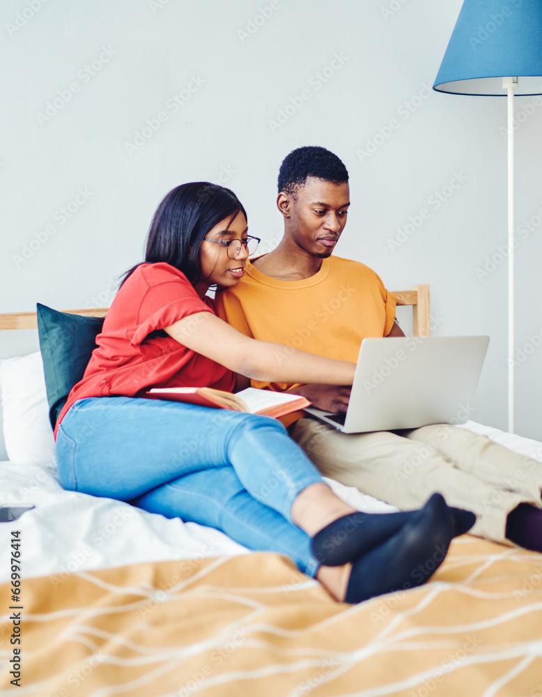 Poster couple browse web page on netbook making booking together at home
