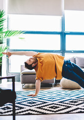 Professional sportive man practising meditation in modern apartment