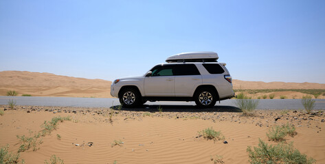 Inner Mongolia ,China - July 24 2021:  Driving White 2020 Toyota 4Runner TRD crossing in the desert road trip