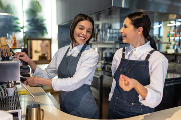 Two young smiling shop assistants working and feeling confident
