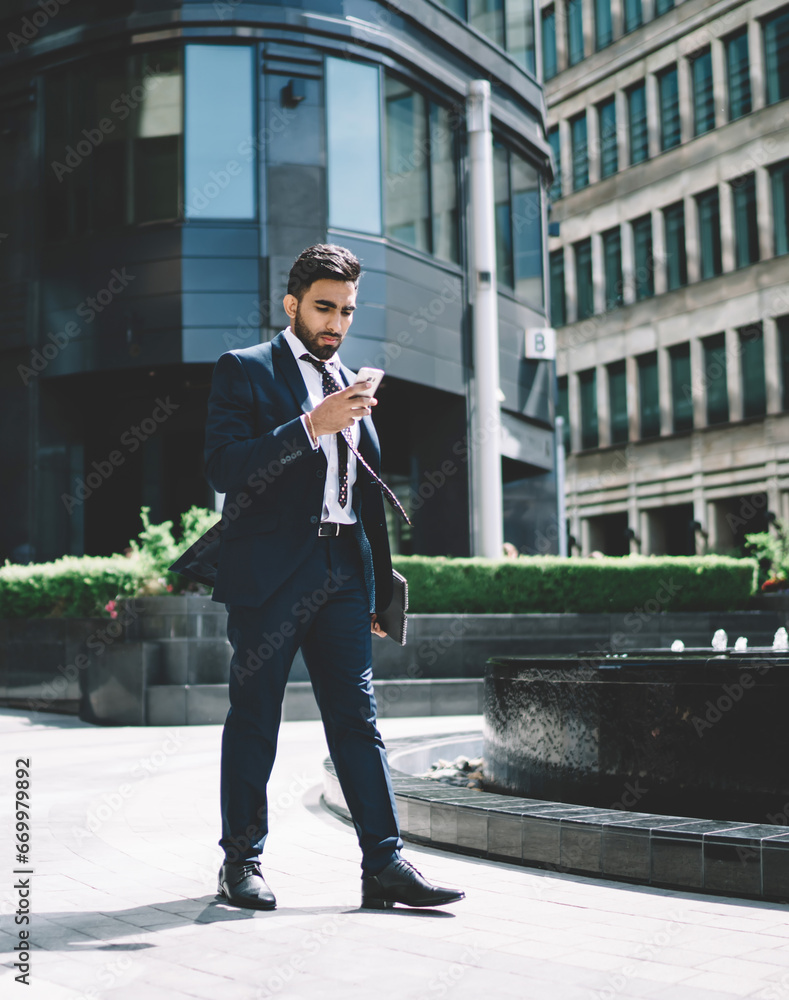 Poster man in formal wear reading email with media files in via smartphone gadget