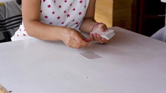 Woman’s hands spreading five tarot cards and flipping them on table