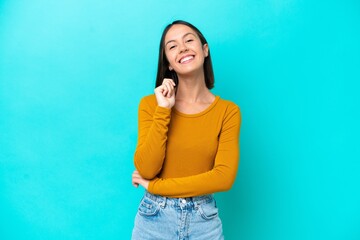 Young caucasian woman isolated on blue background laughing