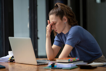 Businesswoman sitting in the office is stressed, working hard, feeling stressed and dizzy from...
