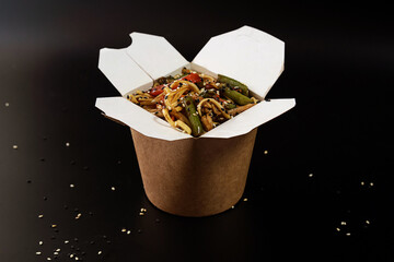 noodles in a box with sesame seeds, sauce and vegetables