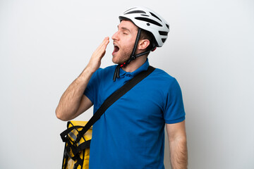 Young caucasian man with thermal backpack isolated on white background yawning and covering wide open mouth with hand