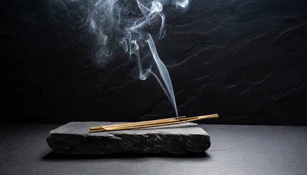 smoke from incense sticks on a empty black stone table with black background high quality photo