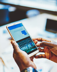 Cropped view of man's hands downloading application on digital smartphone device