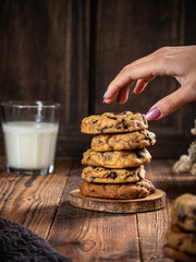 Cookies are stacked neatly on a wooden placemat, isolated with a wooden table background.