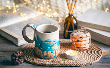 Cozy autumn composition with a handmade cup close-up.