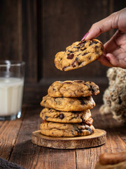 Cookies are stacked neatly on a wooden placemat, isolated with a wooden table background.