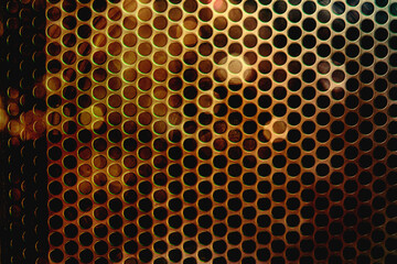Abstract background of steel mesh in front of speakers.