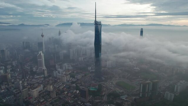 Establishing aerial cinematic b-roll shot of sunrise at Kuala Lumpur city skyline with highest building in Asia