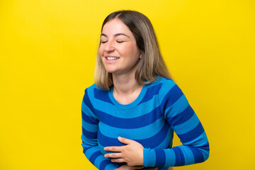 Young Rumanian woman isolated on yellow background smiling a lot