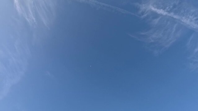 Airplane in blue sky in time lapse and clouds