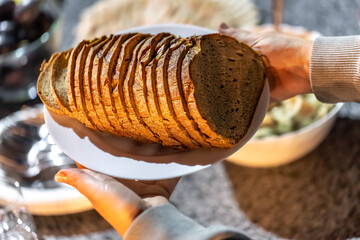 A plate with sliced bread in female hands.