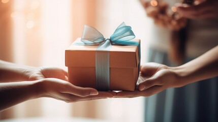 close up of someone holding a gift box tied with a bow