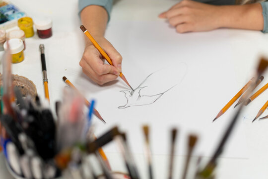 young female artist drawing cartoon on a paper with pencil