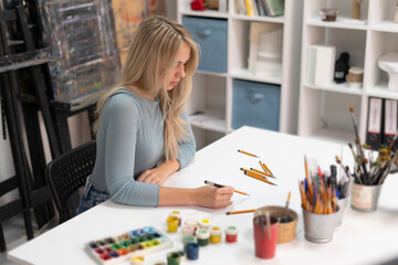 a girl trying painting, making her first paint in the studio