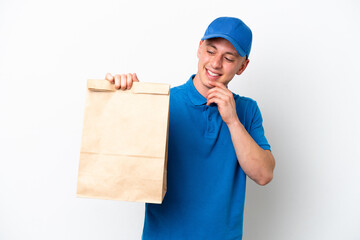 Young Brazilian man taking a bag of takeaway food isolated on white background looking to the side and smiling