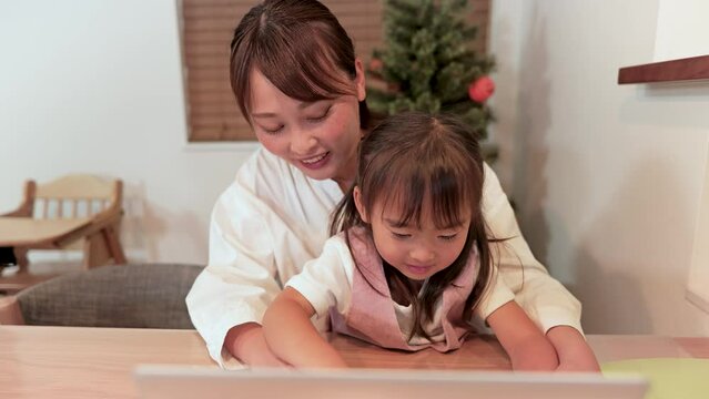お母さんからパソコンを習う女の子