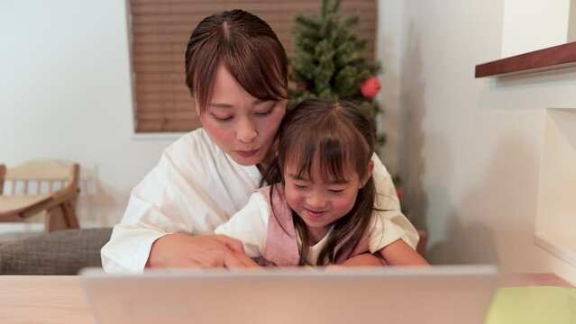 お母さんからパソコンを習う女の子