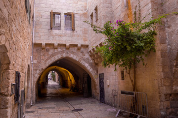 Fototapeta na wymiar The limestone alley and the arch deep in the Old Town of Jerusalem in Israel.