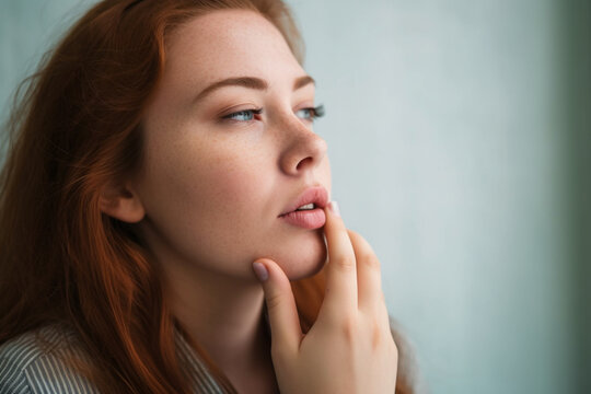 Portrait of a woman looking forward and touching her lip