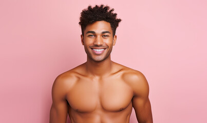 Shirtless black man with curly hair smiles confidently.