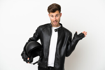 Young caucasian man with a motorcycle helmet isolated on white background with shocked facial expression