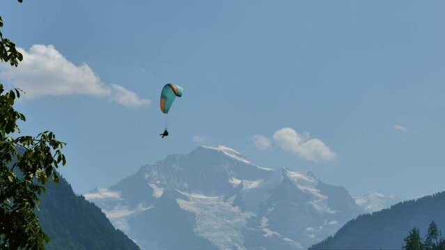 Paragliding and Snowcapped Mountain Peak Jungfraujoch in a Sunny Summer Day in Interlaken, Bernese Oberland, Bern Canton, Switzerland, Europe
