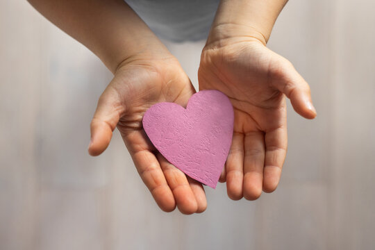 love and kindness, child hands holding paper heart, affection, bonding and care concept