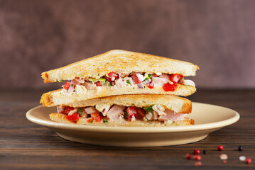 Chopped Italian sandwich in a plate on a brown wooden table.