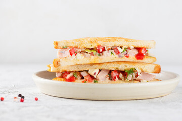 Chopped Italian sandwich with spices on a white table.