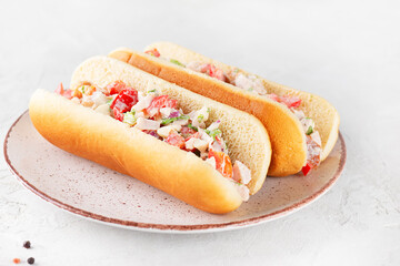 Chopped Italian sandwich in hot dog buns in a plate.