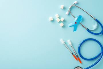 Diabetes Awareness Month solidarity. Overhead shot of diabetes emblem - blue ribbon, insulin syringes, stethoscope, and granulated sugar on a soft blue surface, open for your message