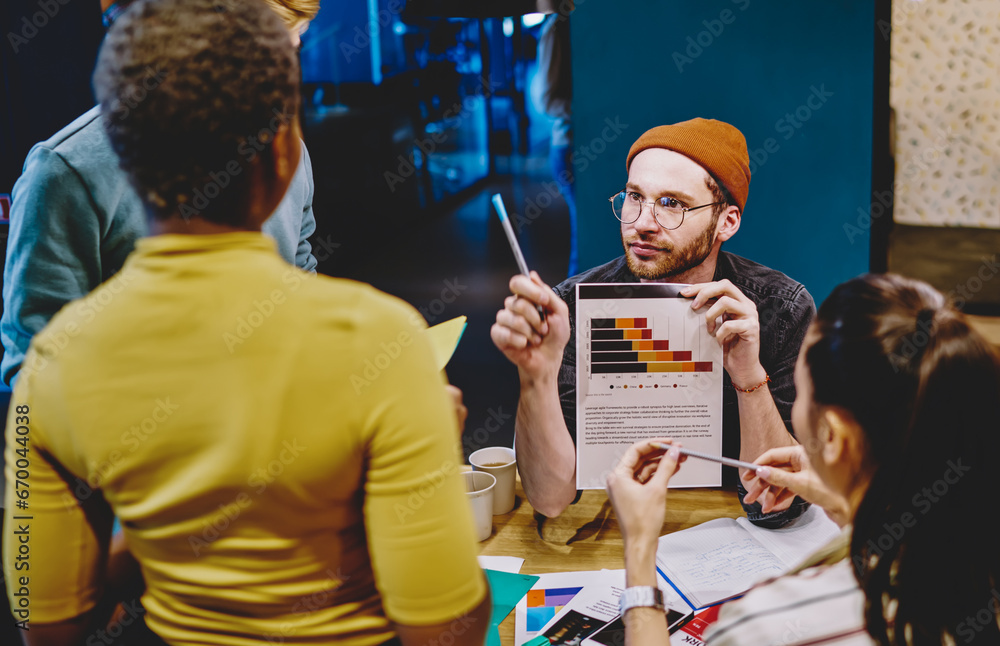 Poster hipster students collaborating with each other and talking about chart