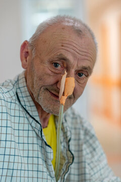 Patient with nasogastric tube on hospital bed waiting for treatment. Positive close up of an elder man waiting for an operation. Enthusiastic approach to hospital treatment.