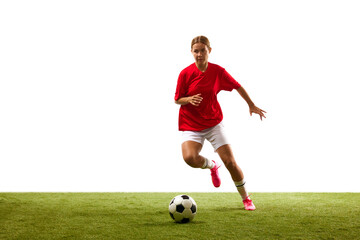 Ball dribbling. Young woman, female football player in motion during game, training on green grass isolated on white background. Concept of sport, competition, action, success. Copy space for ad