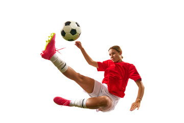 Concentrated game. Young girl, football player hitting ball in motion and falling down isolated on white background. Concept of sport, competition, action, success, motivation. Copy space for ad