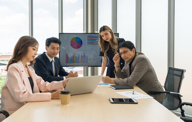 High-powered business professionals discussing strategic plans and making decisions at a conference table in a professional office setting.