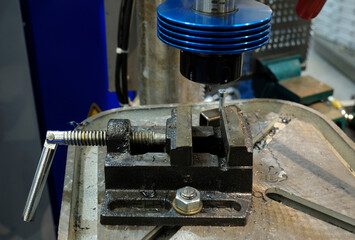 clamp vice and drill of the drilling machine prepared for work, locksmith workplace