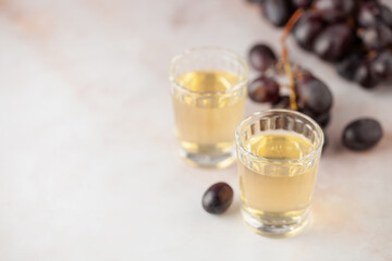 Traditional Georgian  chacha, also known as grape vodka or Georgian grappa in shot glasses  and fresh grapes