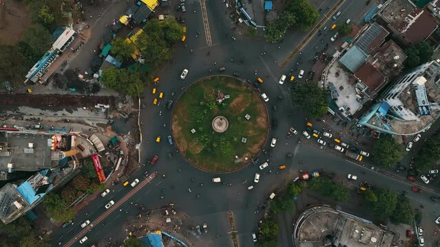 Aerial view of car traffic at the roundabout lane and buildings in Nagpur, Maharashtra, India. Beautiful cinematic shot of Indian City.