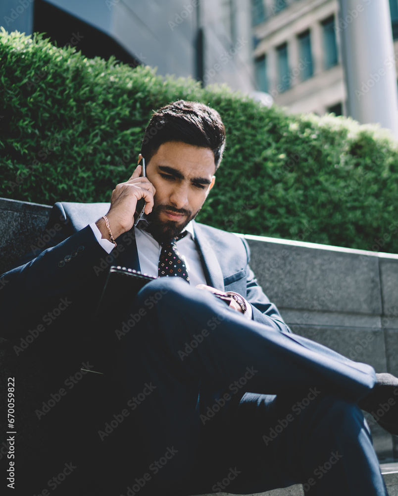 Poster man in formal suit talking with employee about data report
