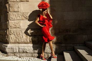 Glamour, elegant woman woman stylized as a rose flower is wearing red Ruffle dress and is posing...